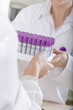 Technician handing vials to co-worker in laboratory