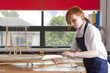 Student in woodworking class working on model airplane
