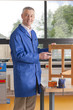 Carpenter in woodshop putting stain on wooden table