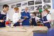 Teacher talking to students in vocational classroom
