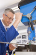 Metalworker using drill in workshop