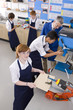 Teacher watching students use saw in woodworking class
