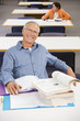 Portrait of smiling senior man studying in library