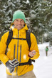 Portrait of smiling hiker holding compass in snowy woods