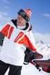 Smiling man standing holding snowboard