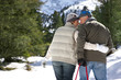 Couple pulling sled in snow covered wilderness
