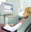 Photo: Girl in dentist's chair looking at x-ray results on computer monitor Girl in dentist's chair looking at x-ray results on computer monitor