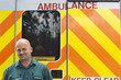 Portrait of smiling paramedic in front of ambulance
