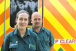 Portrait of smiling paramedics in front of ambulance