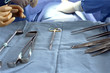 Close up of surgical tools on tray and surgeons in background