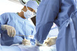 Foto: Focused surgeons operating on patient Focused surgeons operating on patient