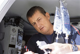 Photo: Close up of paramedic working with intravenous saline drip in emergency airlift helicopter Close up of paramedic working with intravenous saline drip in emergency airlift helicopter