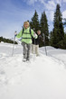 Senior couple walking in snow with ski poles