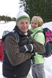 Portrait of senior couple with backpacks and ski poles in snowy woods