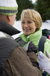 Close up of senior man helping woman with backpack in snowy woods