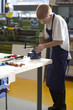 Boy using saw in school workshop