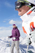 Foto: Smiling couple wearing ski goggles and holding ski poles on snowy mountain Smiling couple wearing ski goggles and holding ski poles on snowy mountain