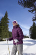 Foto: Smiling woman wearing ski goggles and holding ski poles in snow Smiling woman wearing ski goggles and holding ski poles in snow
