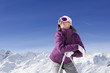 Foto: Smiling woman wearing ski goggles and leaning on ski poles on snowy mountain Smiling woman wearing ski goggles and leaning on ski poles on snowy mountain