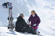 Foto: Senior couple with skis and water bottle sitting on snowy mountain Senior couple with skis and water bottle sitting on snowy mountain