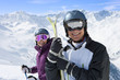 Foto: Portrait of smiling senior couple wearing ski goggles and holding skis on snowy mountain Portrait of smiling senior couple wearing ski goggles and holding skis on snowy mountain