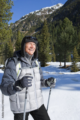Photo: Smiling man with ski poles trekking in snowy woods Smiling man with ski poles trekking in snowy woods