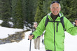 Portrait of smiling couple with ski poles trekking in snowy woods