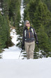 Woman with ski poles trekking in snowy woods