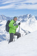 Photo: Portrait of smiling senior man with backpack and ski poles trekking on snowy mountain Portrait of smiling senior man with backpack and ski poles trekking on snowy mountain