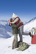 Smiling senior couple hugging face to face on snowy mountain