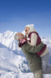 Senior man lifting woman on snowy mountain