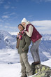 Smiling senior couple hugging on snowy mountain