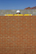 Foto: Portrait of bricklayer holding level tool on brick wall Portrait of bricklayer holding level tool on brick wall