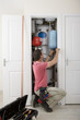 Handyman fixing boiler in closet
