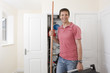 Photo: Portrait of smiling handyman holding toolbox and copper pipes in front of boiler in closet Portrait of smiling handyman holding toolbox and copper pipes in front of boiler in closet