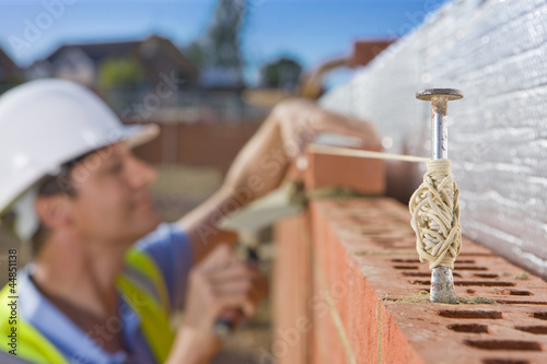 Photo: Bricklayer laying brick wall Bricklayer laying brick wall