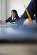 Photo: Students in school uniforms taking exam at desk in classroom Students in school uniforms taking exam at desk in classroom