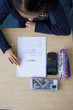Photo: Female student in school uniform looking down at exam on desk Female student in school uniform looking down at exam on desk