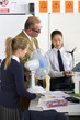 Photo: Teacher and students in school uniforms with wind turbine model in science class Teacher and students in school uniforms with wind turbine model in science class