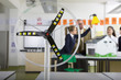 Foto: Close up of wind turbine model in science class with teacher and students in school uniforms in background Close up of wind turbine model in science class with teacher and students in school uniforms in background