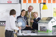 Foto: Teacher and students in school uniforms with wind turbine and solar panel models in science class Teacher and students in school uniforms with wind turbine and solar panel models in science class