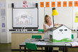 Photo: Female teacher adjusting solar panels on house model in science class Female teacher adjusting solar panels on house model in science class