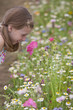 Smiling girl smelling wildflower in field