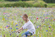 Girl riding bicycle in wildflower field