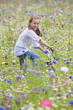 Portrait of smiling girl riding bicycle in wildflower field