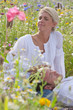 Man laying in womanճ lap in sunny wildflower field