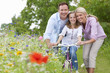 Portrait of family with bicycle in wildflower field