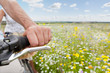 Senior couple riding bicycles on path through field of wildflowers