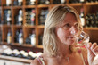 Woman smelling white wine in wine shop