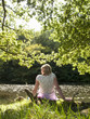 Serene woman relaxing on riverbank